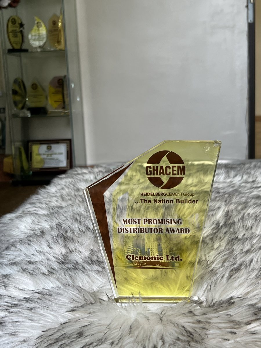 Yellow acrylic trophy with a brown stripe: GHACEM Most Promising Distributor Award, presented to Clemonic Ltd.