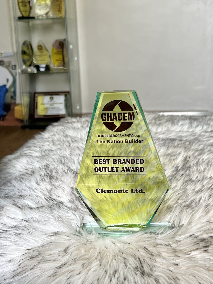 Tall hexagonal green-edged glass trophy: GHACEM Best Branded Outlet Award, presented to Clemonic Ltd.