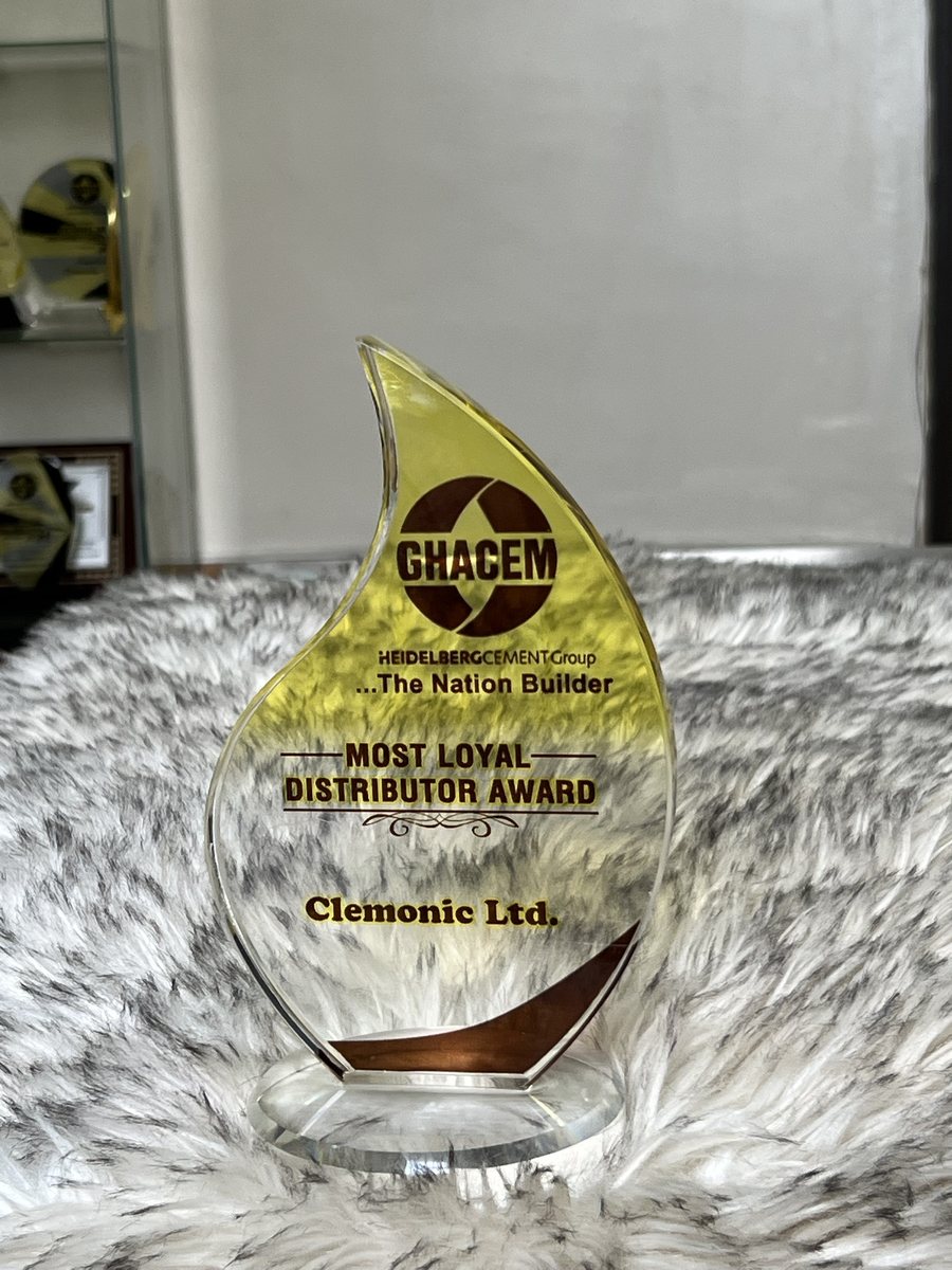 Flame-shaped yellow crystal trophy: GHACEM Most Loyal Distributor Award, presented to Clemonic Ltd.