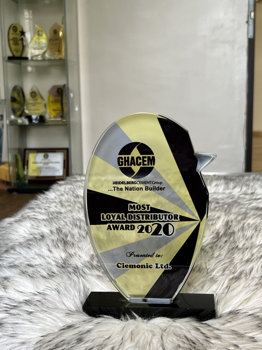 Oval crystal trophy with yellow, black and grey rays on a black base: GHACEM Most Loyal Distributor Award 2020, presented to Clemonic Ltd.