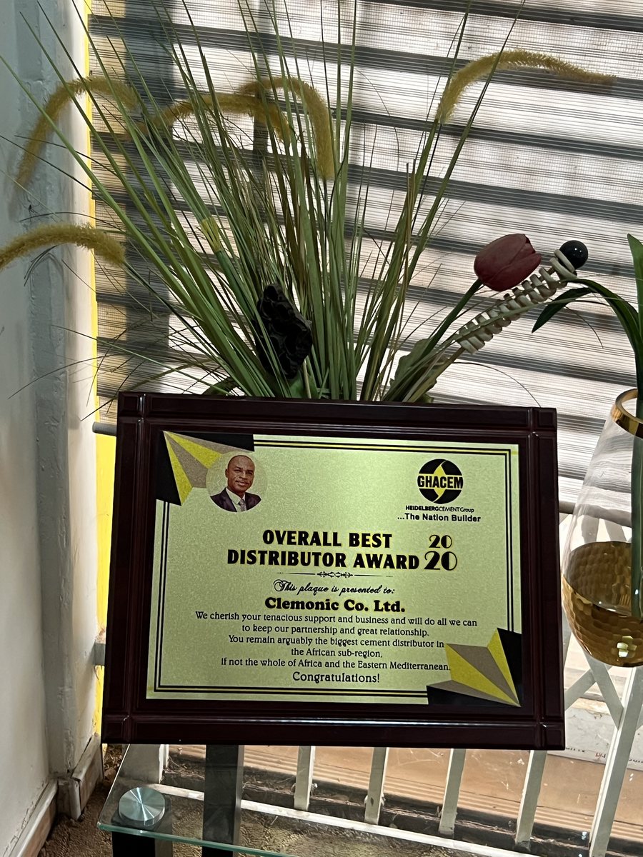 Wooden plaque: GHACEM Overall Best Distributor Award 2020, presented to Clemonic Co. Ltd. — We cherish your tenacious support and business and will do all we can to keep our partnership and great relationship. You remain arguably the biggest cement distributor in the African sub-region, if not the whole of Africa and the Eastern Mediterranean. Congratulations!
