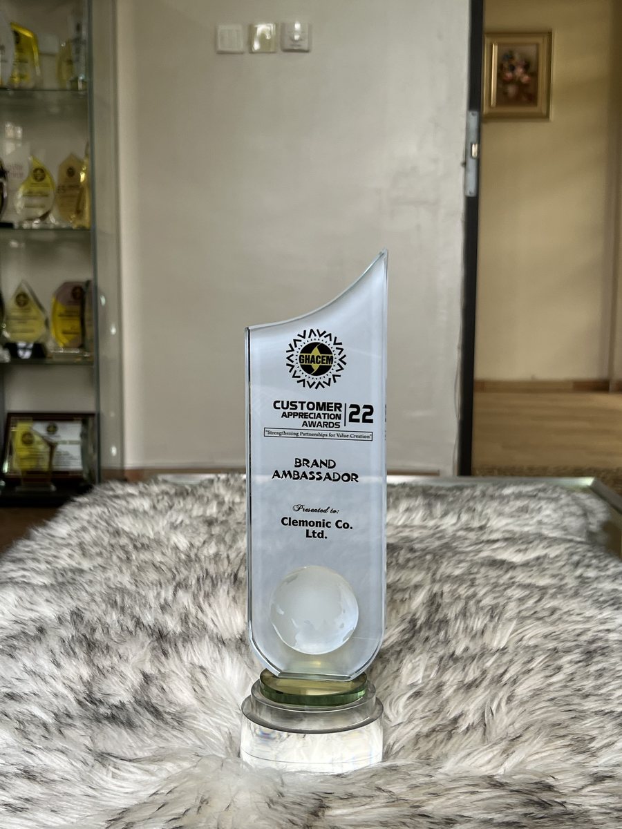 Frosted glass trophy with a crystal globe on a green glass base: GHACEM Customer Appreciation Awards 2022 — Brand Ambassador, presented to Clemonic Co. Ltd.